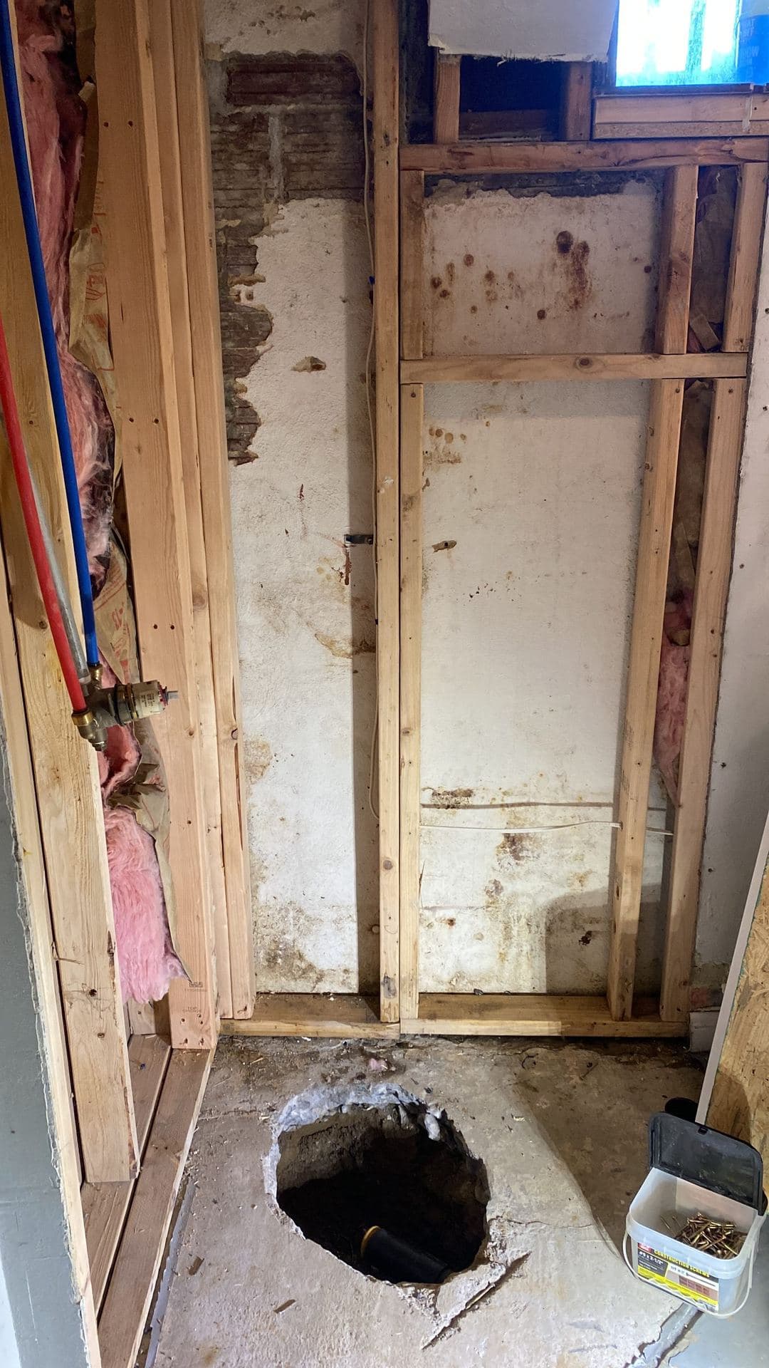 Basement remodel with a new stud wall, PEX plumbing lines, and insulation