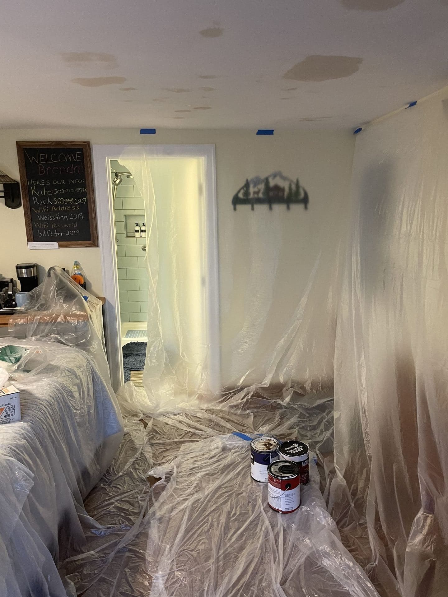 Room masked in plastic while ceiling drywall patches are mudded