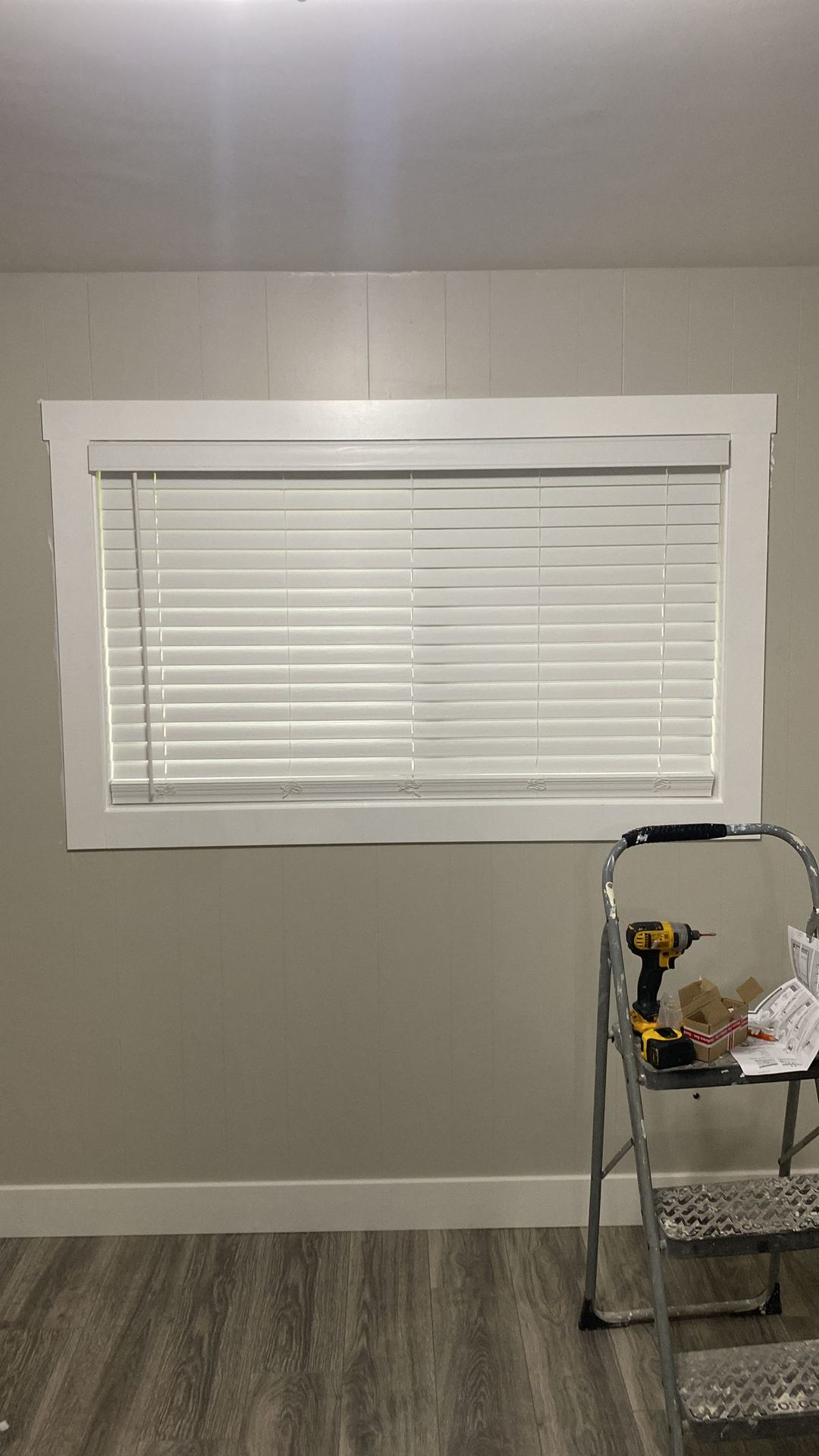Finished interior window with white craftsman-style trim and blinds